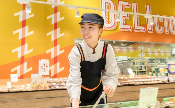 従業員が店頭でお客様のほうへ笑顔を向けている様子
