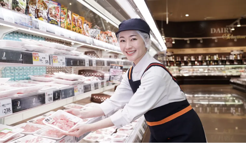 精肉担当の従業員が、パックを店頭に並べている様子
