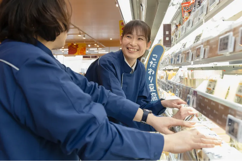 A.A.さんが他の従業員と一緒に商品整理をしながら会話している様子