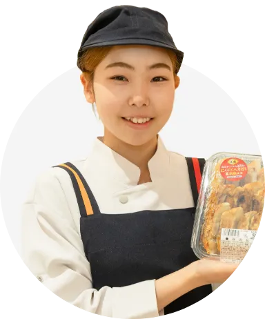 お勧め商品の「豚肉餃子」を手に持ち、正面を向くM.A.さんのバストアップ写真
